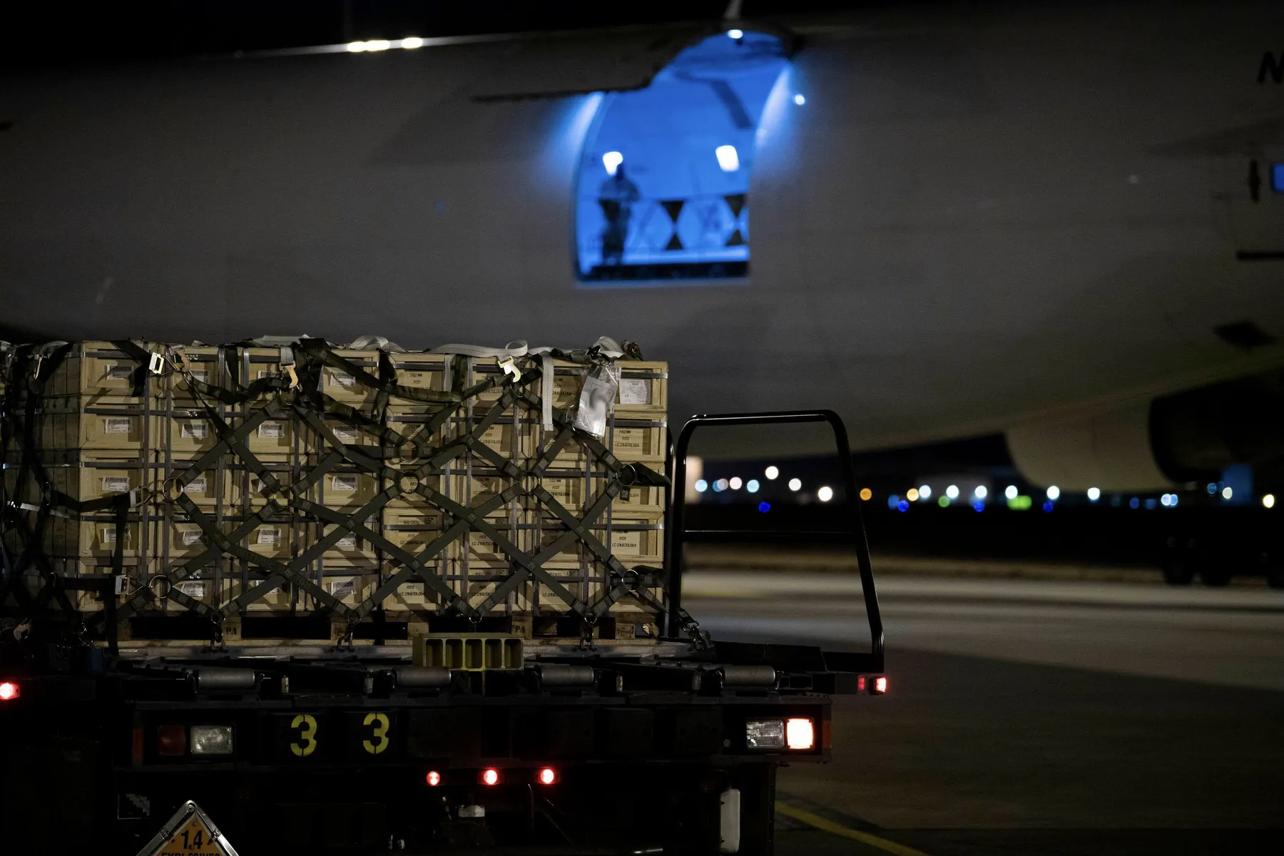 Palletized crates loaded on a truck for airlift at night